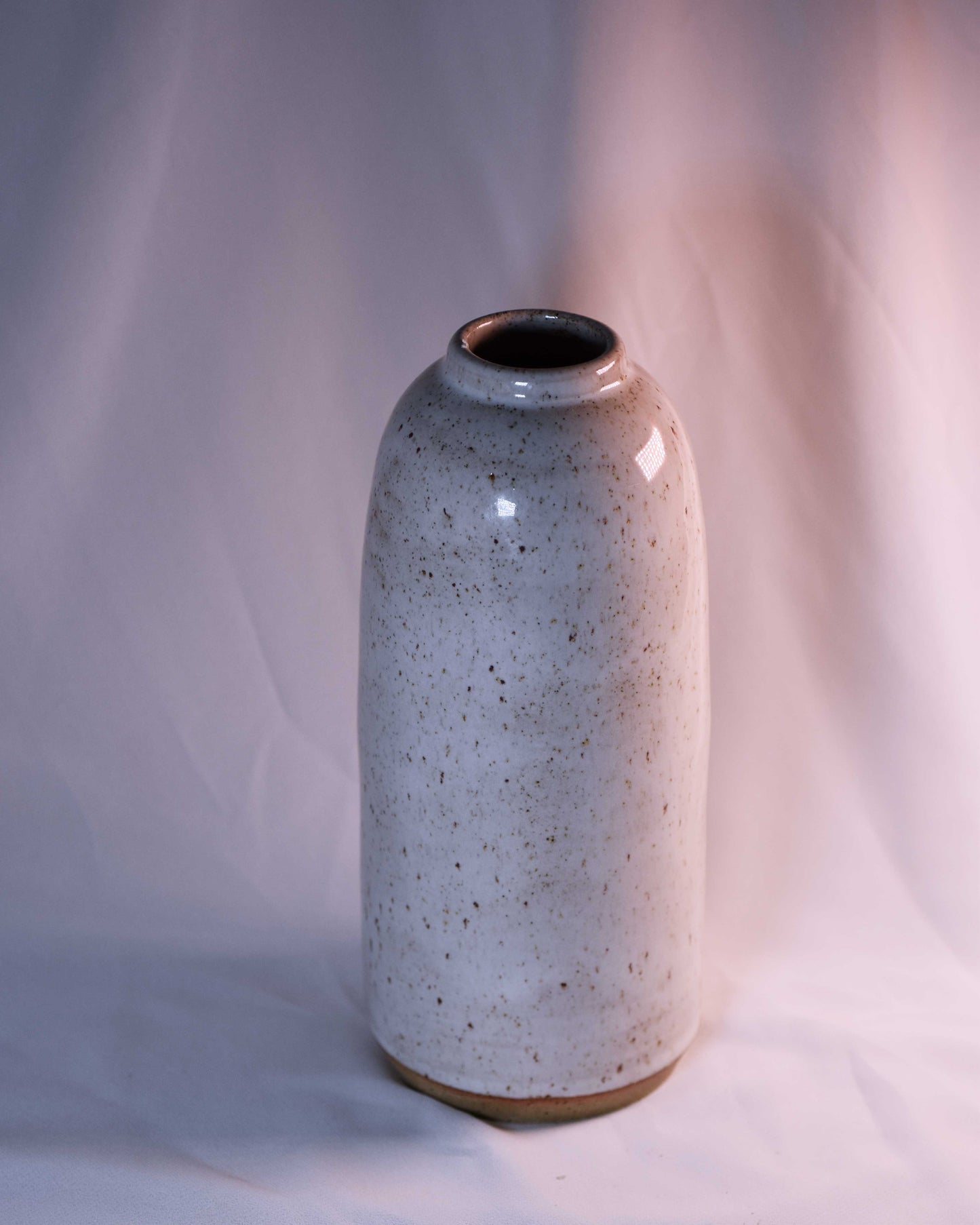 Speckled ceramic vase on a plain background