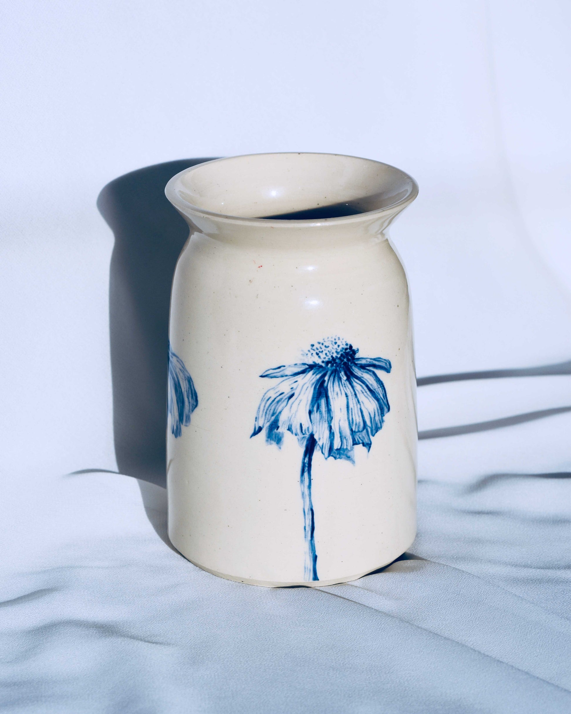White ceramic vase with floral decoration on white background. 