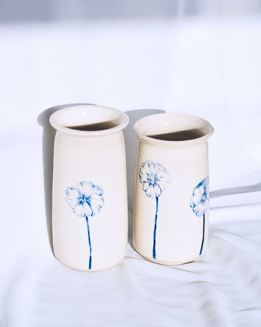 Two ceramic floral vases with pansy illustrationson a white background 