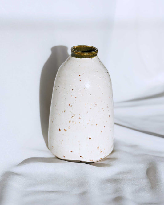 Speckled white ceramic vase on a light background