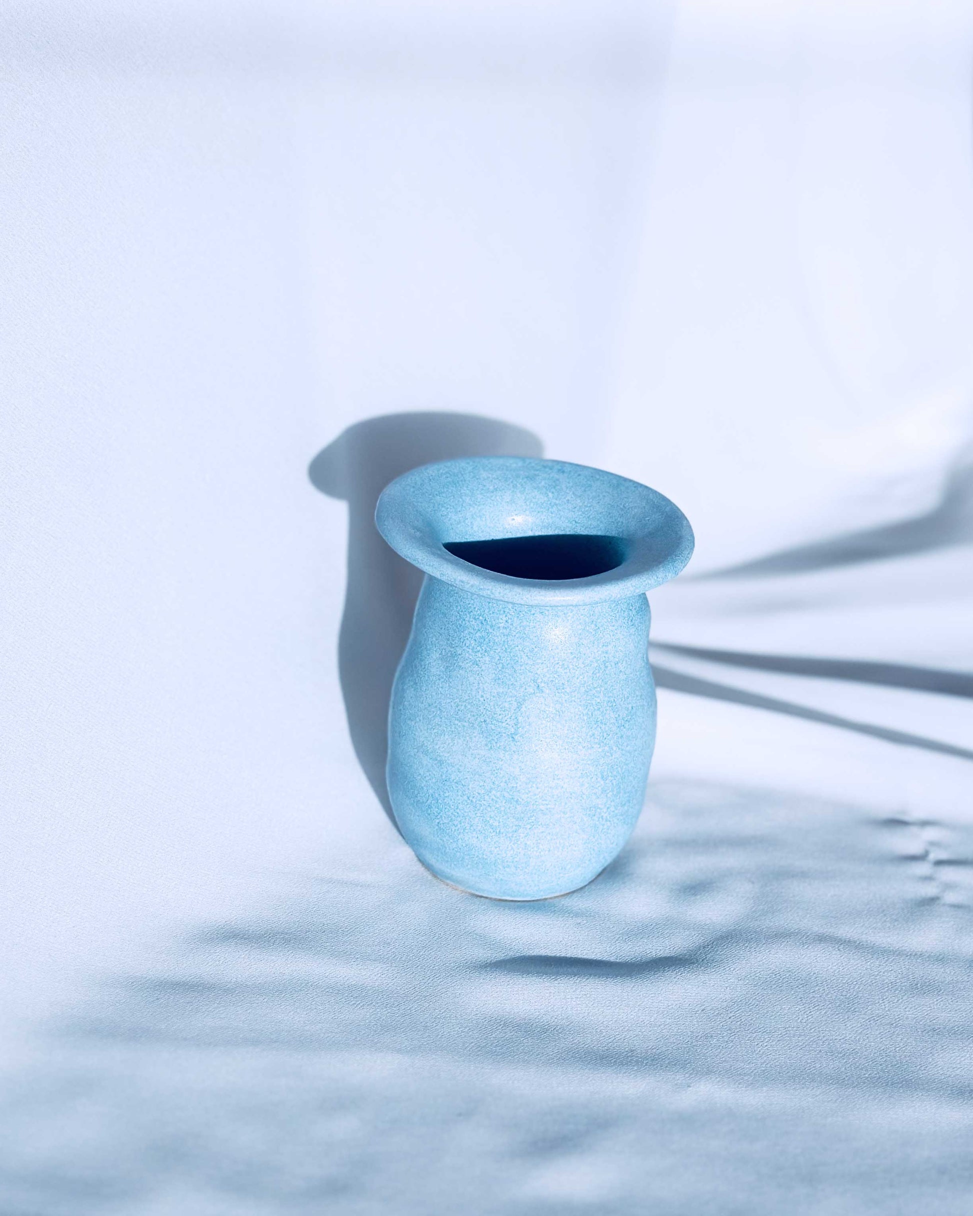 Blue ceramic vase on white background